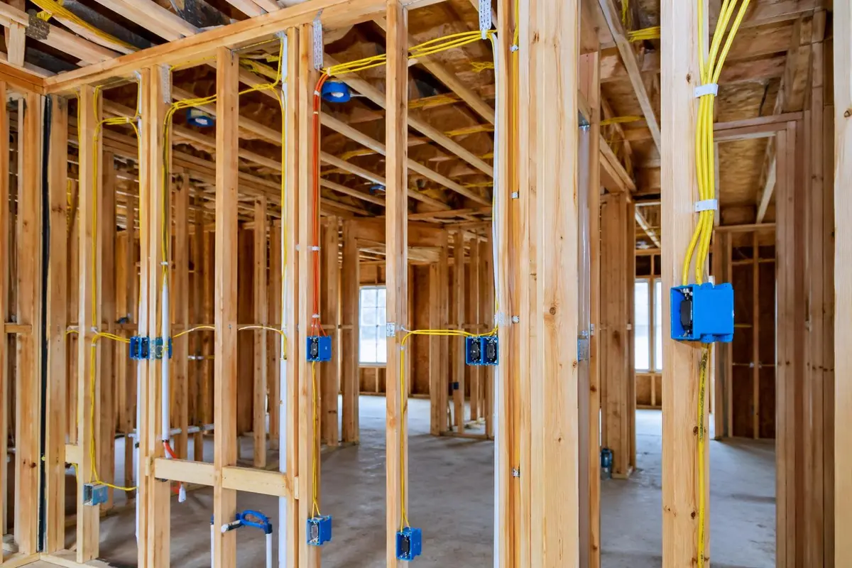 Whole-home rough-in wiring — Romex through framing, blue boxes mounted square, NEC 2023 compliant